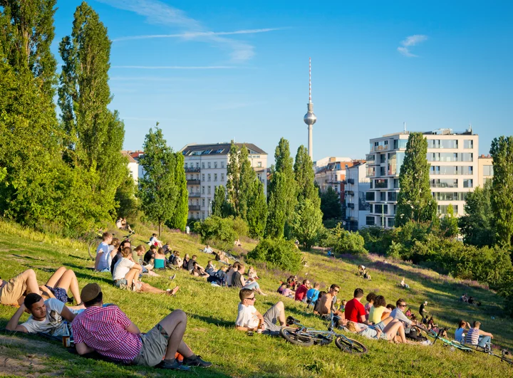 Stadtansicht Berlin mit Park und Menschen im Vordergrund und Fernsehtürm im Hintergrund