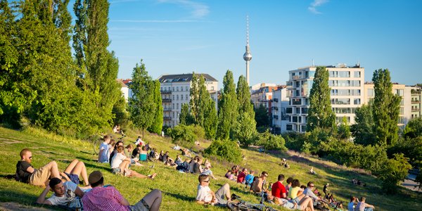 Stadtansicht Berlin mit Park und Menschen im Vordergrund und Fernsehtürm im Hintergrund