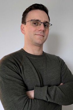 Profilfoto von Max, Mann mit Brille und verschränkten Armen lächelt in die Kamera