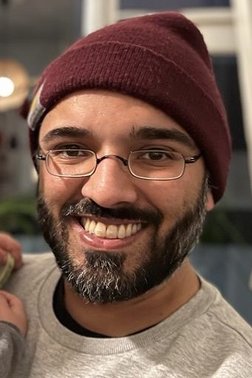 Profilfoto von Samir, Mann mit Käppi, Brille und Vollbart schaut lächelnd in die Kamera