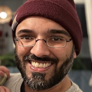 Profilfoto von Samir, Mann mit Mütze, Brille und Vollbart schaut lächelnd in die Kamera